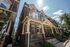 Charming Victorian row house with elegant brick facade and inviting front porch under a clear blue sky.