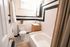 Charming bathroom with elegant black and white tiles, featuring a cozy tub, modern vanity, and bright natural light.