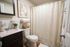Chic bathroom with a modern sink, stylish artwork, and elegant shower curtain, ideal for relaxation and daily comfort.