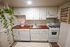 Charming kitchen with white cabinets, a cozy wood countertop, hanging green plant, and neatly organized spices.