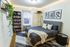 Cozy bedroom with a stylish gray bed set, vibrant wall art, and a flourishing green plant accentuating a serene ambiance.