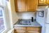 Cozy kitchen nook with classic wooden cabinets, sleek granite countertops, and a modern stainless steel sink, perfect for efficient cooking.