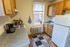 Cozy kitchen with warm wooden cabinets, granite countertops, and modern appliances, featuring a charming window view.