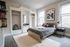 Inviting bedroom with modern decor, featuring a comfortable bed, ample natural light from two large windows, and built-in shelving for optimal storage.