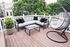 Chic rooftop patio featuring comfortable sectional seating, modern hanging chair, and lush greenery, perfect for relaxing and enjoying scenic views.