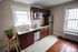 Charming kitchen with rich wooden cabinets, modern appliances, and a cozy window-side plant.