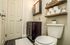 Charming bathroom with sleek vanity, rustic wooden shelves, and modern decor, featuring soft lighting and elegant tile flooring.
