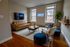 Chic urban living room with stylish brown leather sofa, modern decor, and vibrant 'Philly' neon sign, offering a cozy yet sophisticated atmosphere.