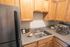 Charming kitchen corner with sleek granite countertops, modern espresso machine, and cozy spice jars enhancing the inviting atmosphere.