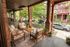 Charming porch with stylish seating, lush greenery, and vibrant urban views, perfect for relaxation and outdoor enjoyment.