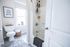 Bright, modern bathroom with elegant decor, featuring a plush rug, stylish wall art, and a spa-like shower area.