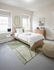 Bright and inviting bedroom with a cozy wooden bed, soft green and white rug, and modern decor, perfect for relaxation.