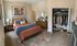 Inviting bedroom with stylish decor featuring a cozy bed, elegant artwork, and spacious closet showcasing organized clothing and shoes.