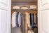 Spacious walk-in closet with neatly arranged clothes, showcasing ample storage and organization potential.