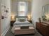 Inviting bedroom featuring a cozy bed with throw pillows, soft lighting, elegant wall art, and a modern dresser with a stylish mirror.