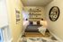 Cozy bedroom showcasing modern decor with a comfortable bed, geometric rug, and elegant wall shelves.