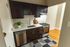 Elegant kitchen featuring dark wood cabinets, modern stainless steel appliances, and a stylish patterned rug, creating a sophisticated cooking space.