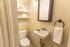 Chic powder room with modern fixtures, elegant shelving, and a cozy ambiance.