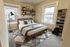 Inviting bedroom with modern decor, cozy queen-size bed, stylish geometric rug, and abundant natural light.