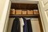 Elegant closet with organized woven baskets and neatly hung clothing, showcasing ample storage space and stylish functionality.