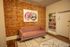 Chic living room with exposed brick wall, cozy pink sofa, and stylish art piece enhancing urban elegance.