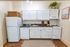 Charming kitchen with white cabinetry, sleek countertops, and a cozy ambiance, ideal for culinary creativity.