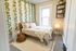 Charming bedroom with lush ivy wall, cozy bed, and soft lighting creating a serene retreat.