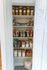 Beautifully organized pantry showcasing labeled glass jars, wire baskets with snacks, and neat storage containers.