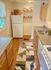Charming kitchen featuring modern appliances, sleek countertops, elegant cabinetry, and a stylish rug for a cozy atmosphere.