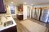 Modern kitchen with sleek stainless steel appliances, warm wooden cabinetry, and elegant countertops, offering a bright and inviting space.