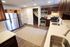 Modern kitchen with stainless steel appliances, elegant dark wood cabinets, and a cozy rug accenting the spacious layout.