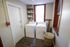 Bright and efficient laundry room featuring modern washer and dryer, stylish shelving with storage jars, and a chic woven basket against a soothing neutral backdrop.