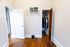 Inviting closet area with polished wooden floors, showcasing organizational shelving and bright, neutral walls.