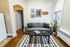 Charming living room with cozy gray sofa, green accents, and stylish wall art, perfect for relaxation and comfort.