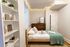 Cozy bedroom with elegant string lights, wooden bed, and modern decor exuding warmth and style.