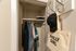 Cozy closet with hanging clothes and stylish accessories, perfect for organized storage in a vibrant urban apartment.