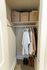 Modern closet with organized storage boxes, hanging garments, and neatly arranged shoes for efficient use of space.