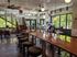 Chic, modern cafe interior with sleek bar seating, vibrant natural light, and a stylish staircase, creating an inviting atmosphere for relaxation and conversation.