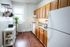 Charming kitchen with wooden cabinets, sleek countertop, and stainless steel appliances, bathed in natural light.