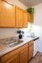 Charming kitchen with warm wooden cabinets, sleek countertops, and a cozy stove, perfect for culinary creativity.