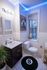 Charming bathroom with stylish lighting, a sleek vanity, vintage movie poster, playful decor, and a cozy window for natural light.
