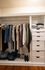 Elegant and organized closet featuring stylish clothing, neatly folded jeans, and shoes, complemented by ample drawer space.