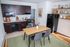Chic kitchen with dark wood cabinets, modern appliances, and cozy dining area on a stylish rug.