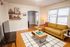 Inviting living room with a mustard-yellow sofa, stylish coffee table, and cozy decor, perfect for relaxation and leisure.