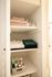 Elegant linen closet with neatly folded towels, organized clothing, and a selection of toiletries, creating a sense of luxury and convenience.