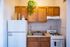 Charming kitchen with warm wooden cabinets, a cozy white stove, and an inviting fridge, perfect for culinary creativity.