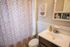 Chic bathroom with stylish leopard print shower curtain, modern vanity, and elegant art piece, creating a cozy and inviting atmosphere.