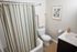 Charming bathroom with elegant striped shower curtain, modern sink, and tasteful botanical decor.