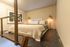 Cozy loft bedroom with modern decor, featuring a stylish bed, minimalist artwork, and warm ambient lighting.