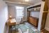 Chic and cozy home office featuring a modern wooden desk, elegant chair, stylish lighting, and ample storage space with a built-in shelving unit and drawers.